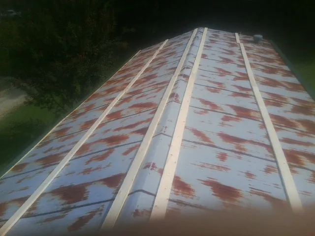 Rusted metal roof panels with new wood purlins before replacement — Storm Damage Roof Repair in Waterport by Roofing Brothers